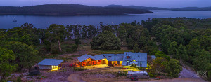 Overhead view of Bruny Island Lodge at night, with the D'Entrecasteaux Channel in the background and Greater Taylors Bay